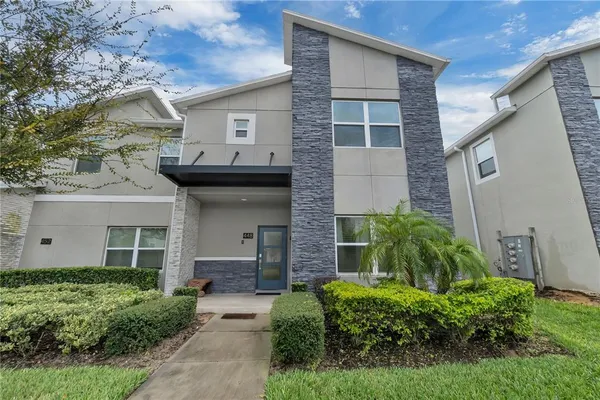 a view of a house with brick walls and a yard with plants