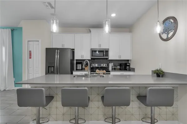 a kitchen with stainless steel appliances granite countertop a sink a stove and a refrigerator