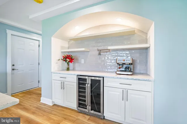 a kitchen with stainless steel appliances granite countertop a sink a stove and a wooden floors