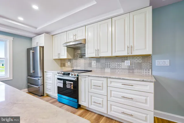 a kitchen with stainless steel appliances granite countertop a stove and cabinets