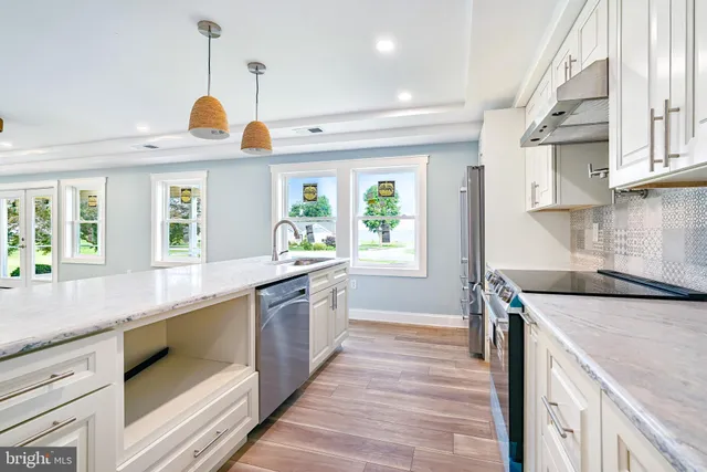 a kitchen with kitchen island a sink and a stove