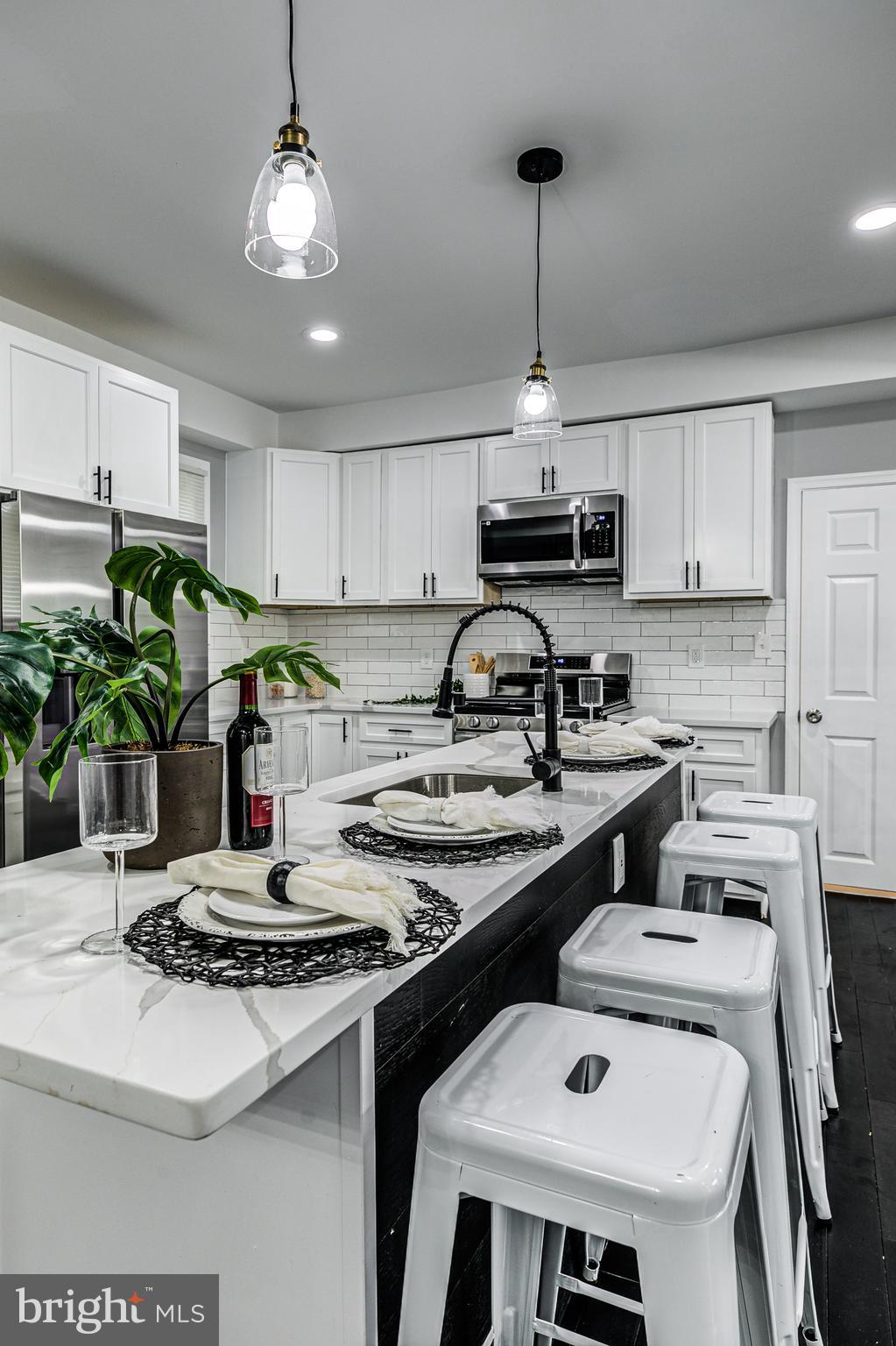5011 Catalpha Road Baltimore, MD 21214 - Photo 17 of 42 a kitchen with a stove a sink and a white cabinets
