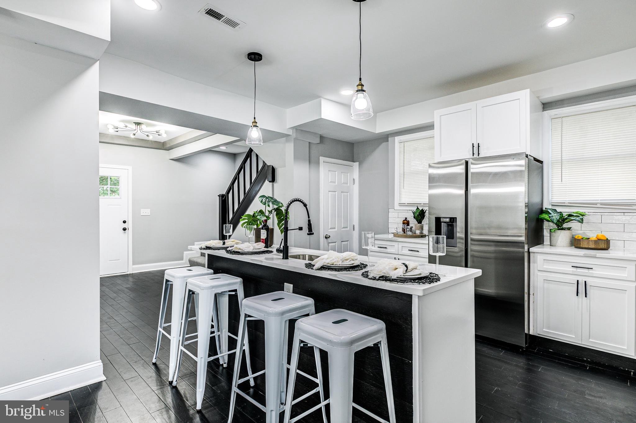 5011 Catalpha Road Baltimore, MD 21214 - Photo 20 of 42 a kitchen with a center island a counter space stainless steel appliances and cabinets