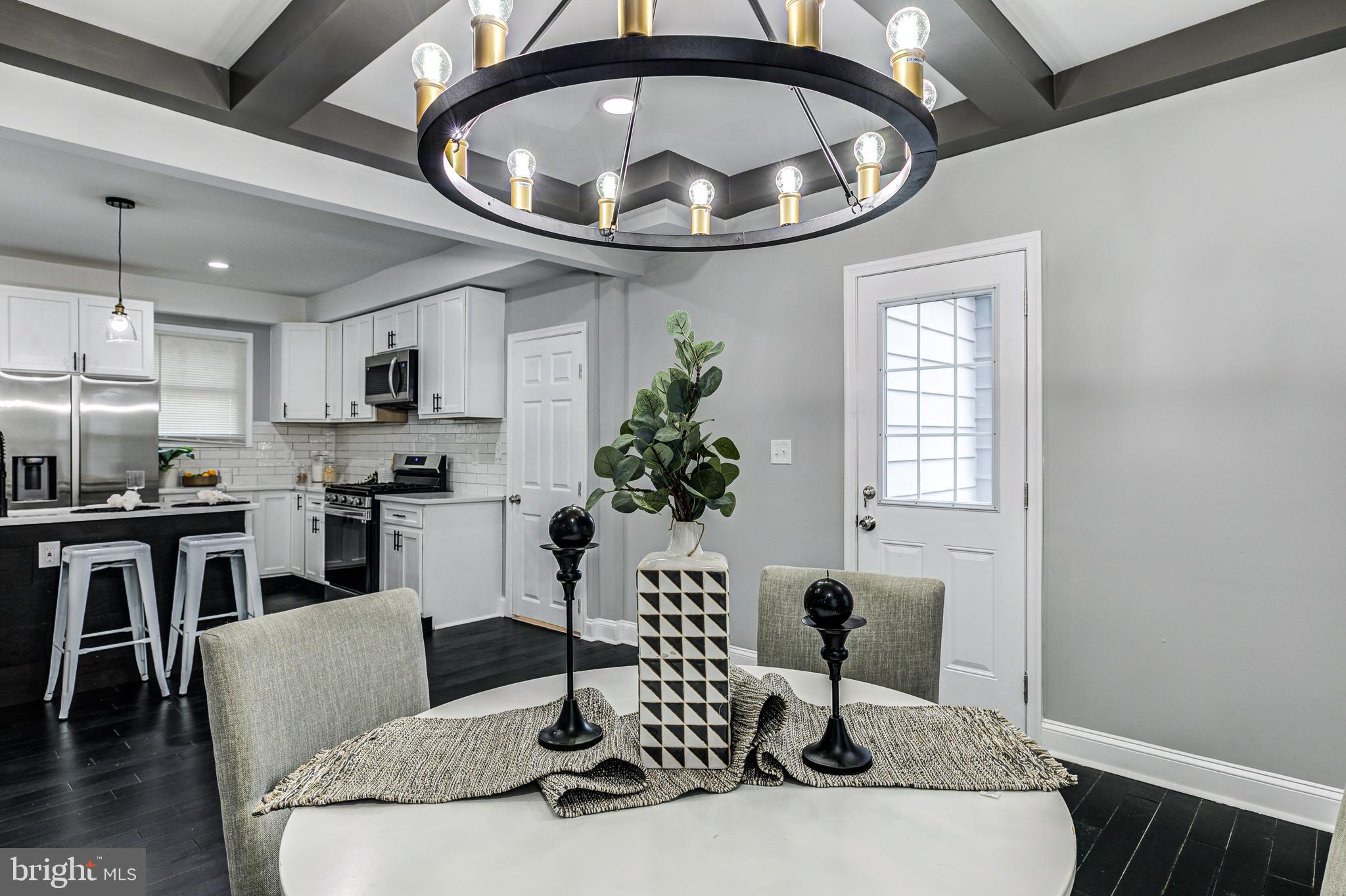 5011 Catalpha Road Baltimore, MD 21214 - Photo 22 of 42 a living room with furniture a chandelier and kitchen view