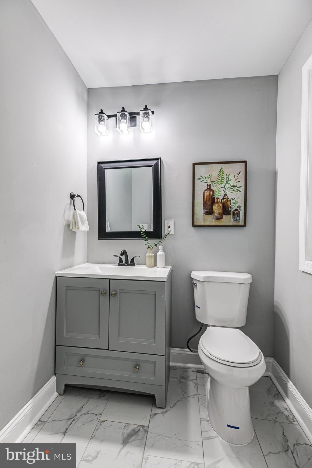 5011 Catalpha Road Baltimore, MD 21214 - Photo 23 of 42 a bathroom with a toilet sink and mirror