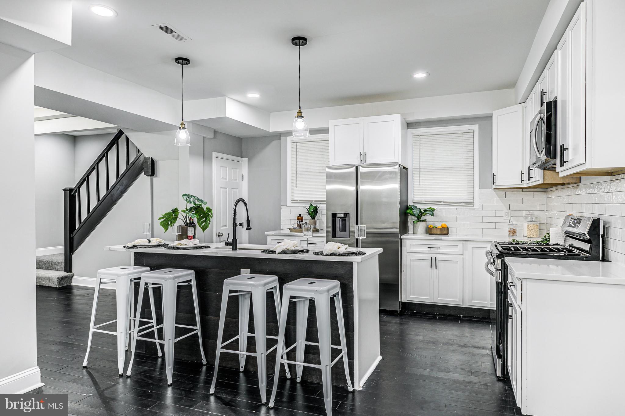 5011 Catalpha Road Baltimore, MD 21214 - Photo 25 of 42 a kitchen with kitchen island granite countertop a sink a counter space appliances and cabinets