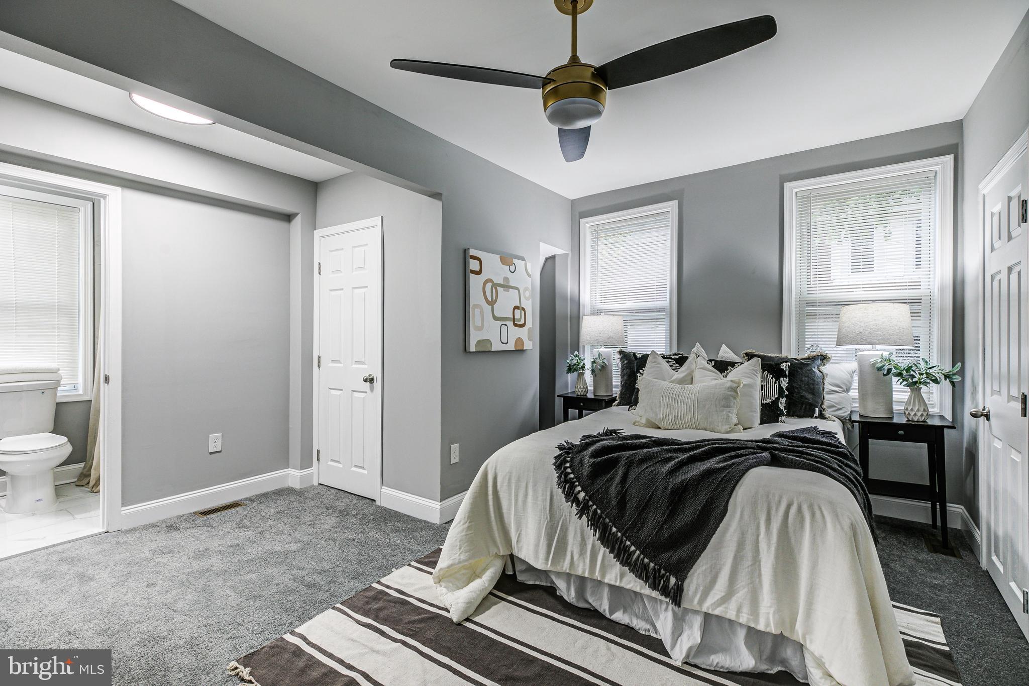 5011 Catalpha Road Baltimore, MD 21214 - Photo 26 of 42 a bedroom with a large bed and a chandelier