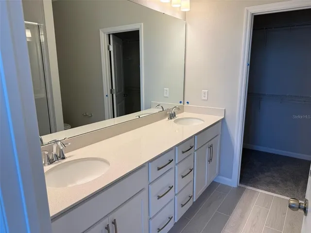 a bathroom with a double vanity sink and mirror