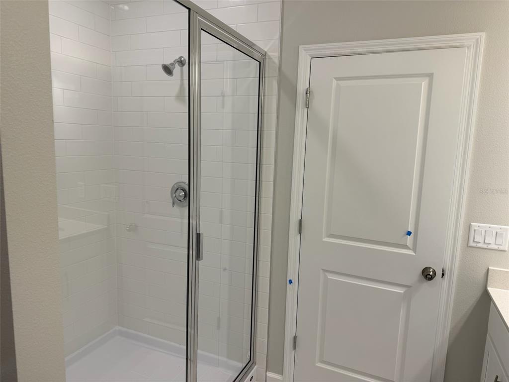 611 Pothos Street Apopka, FL 32703 - Photo 22 of 34 a bathroom with a glass shower door
