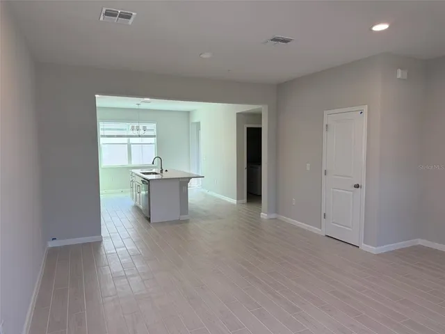 a view of a big room with wooden floor and windows