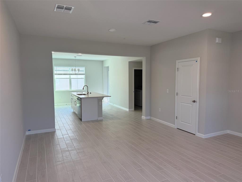611 Pothos Street Apopka, FL 32703 - Photo 3 of 34 a view of a big room with wooden floor and windows