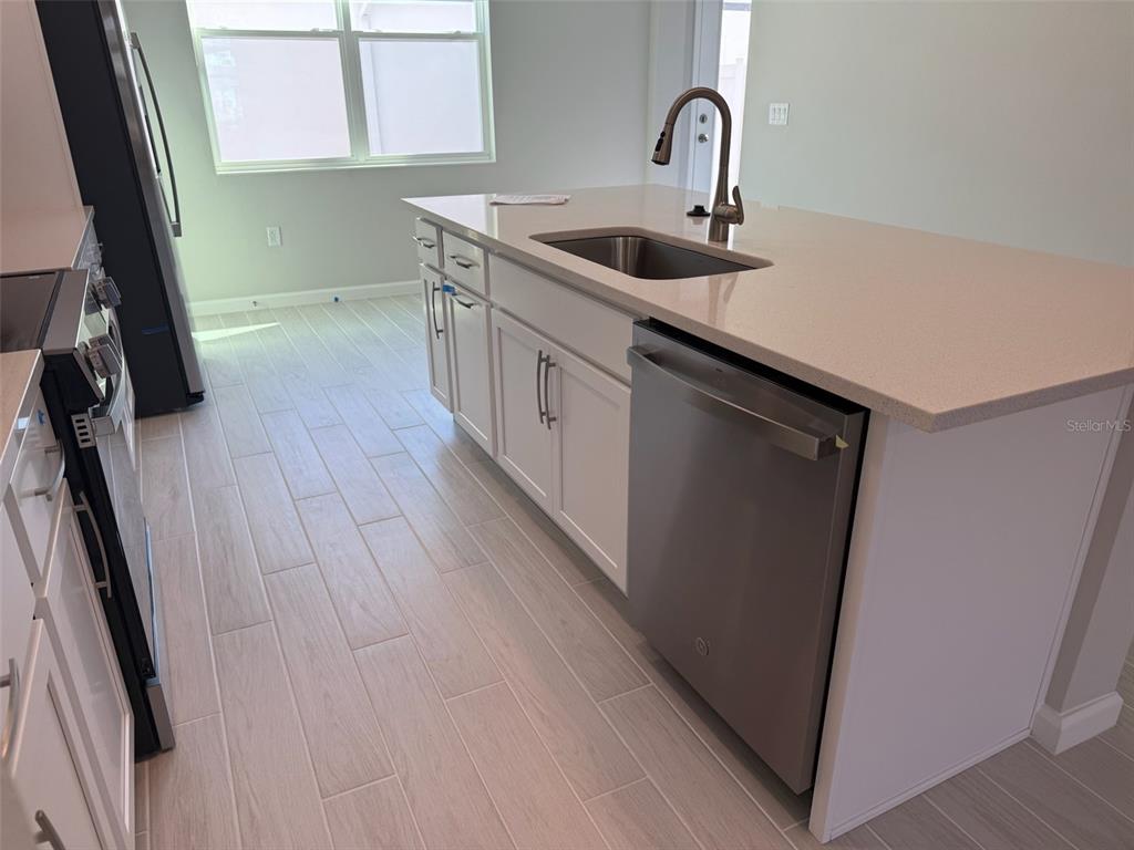 611 Pothos Street Apopka, FL 32703 - Photo 7 of 34 a kitchen with sink a window and appliances
