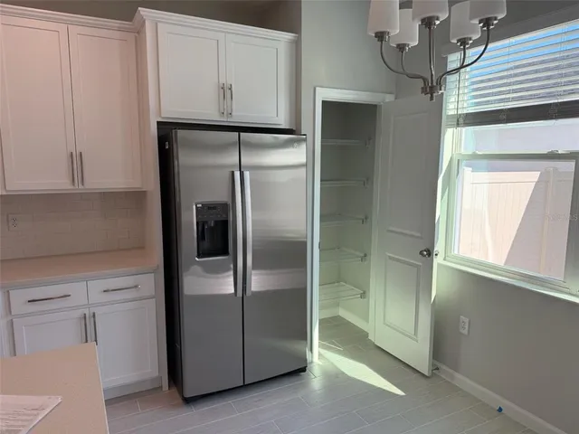 a metallic refrigerator freezer sitting in a kitchen