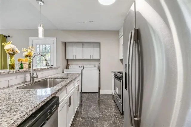 a kitchen with stainless steel appliances granite countertop a refrigerator and a sink