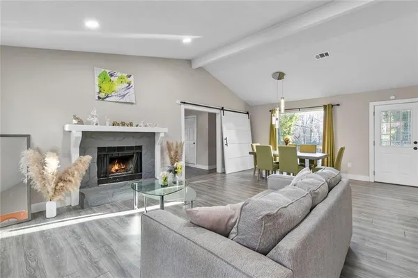a living room with furniture a fireplace and a window