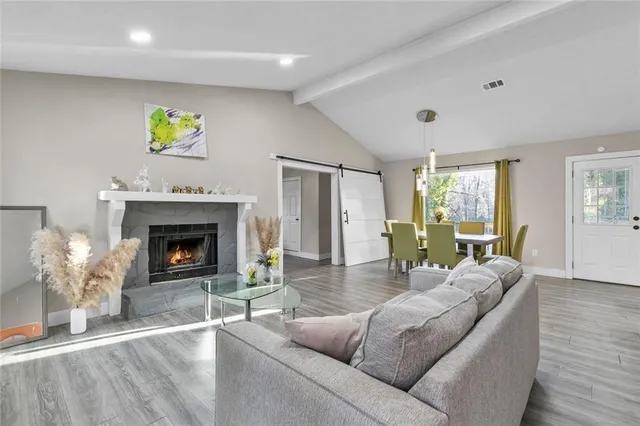 a living room with furniture a fireplace and a window