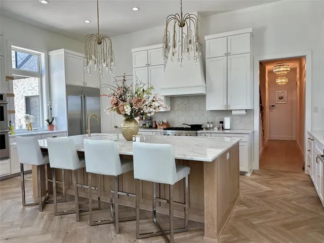 a kitchen with stainless steel appliances kitchen island granite countertop a table and chairs in it