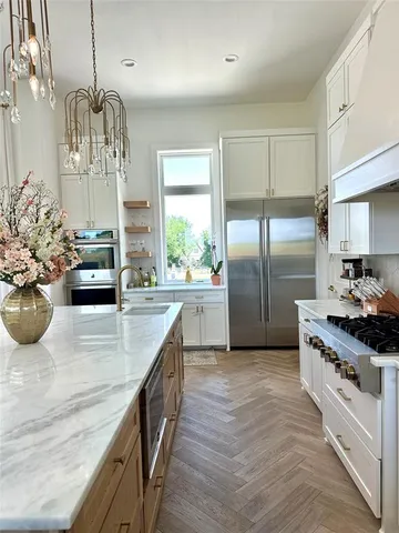 a kitchen with stainless steel appliances granite countertop a sink a stove and a refrigerator