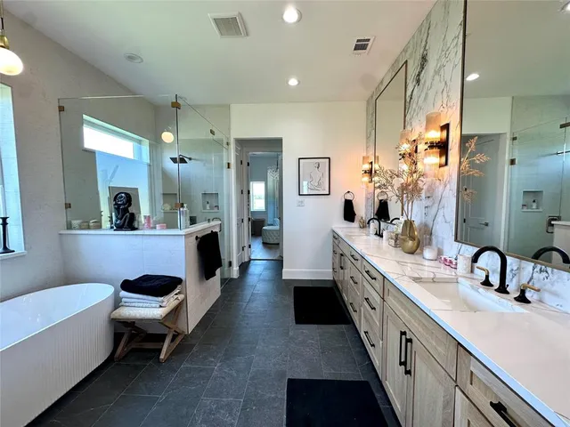 a large bathroom with a double vanity sink a mirror and a bathtub