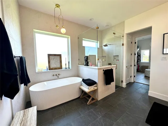 a bathroom with a double vanity sink mirror and bathtub