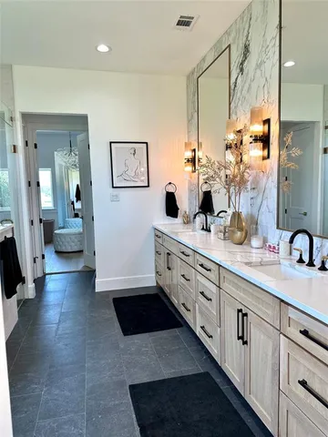 a bathroom with double vanity and a mirror