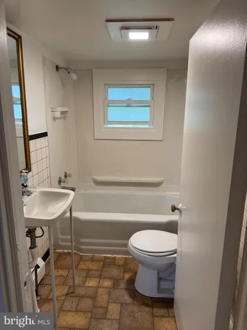 a bathroom with a toilet a sink and a mirror