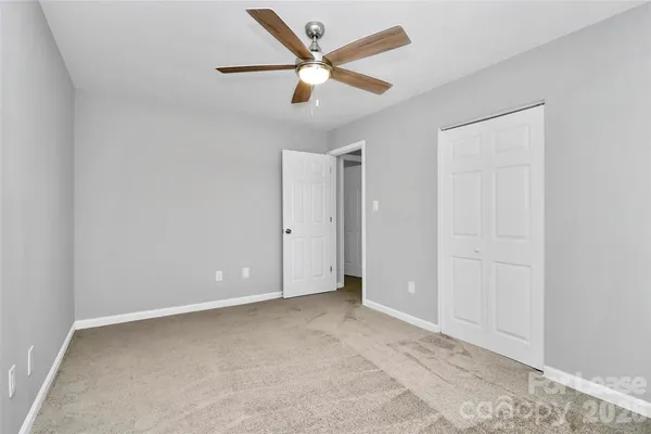 an empty room with closet and fan