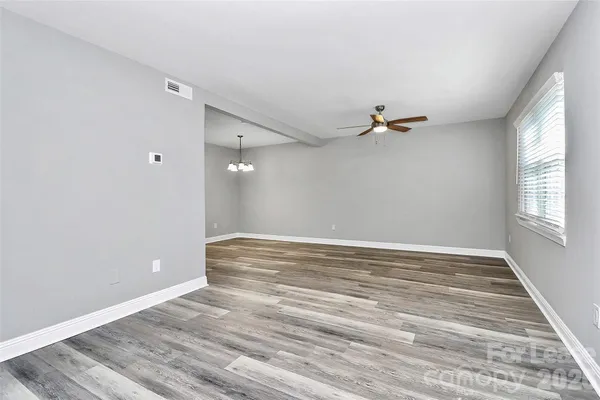 a view of a room with wooden floor and a ceiling fan