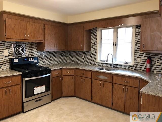 17 Clausen Road Edison, NJ 08817 - Photo 3 of 18 a kitchen with granite countertop a stove sink and cabinets