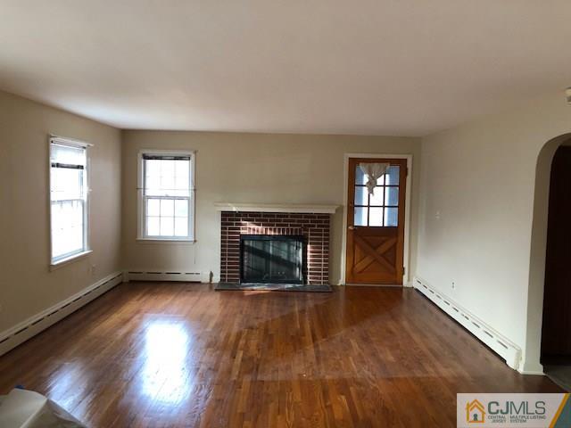 17 Clausen Road Edison, NJ 08817 - Photo 8 of 18 an empty room with wooden floor fireplace and windows