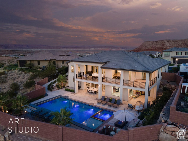 6026 Zen Trail Way St. George, UT 84790 - Photo 29 of 41 Back of property featuring a balcony, an outdoor hangout area, a patio, stucco siding, and a pool with connected hot tub