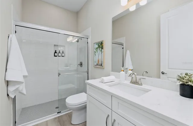 a bathroom with a sink a toilet and shower