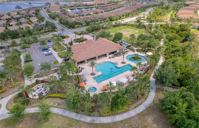 an aerial view of residential houses with outdoor space and lake view