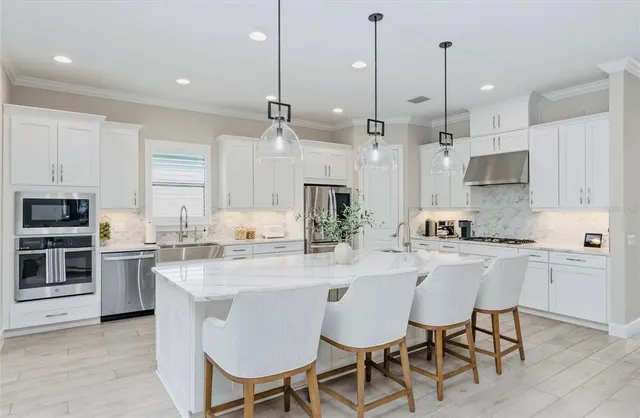 a kitchen with stainless steel appliances granite countertop a stove top oven a sink refrigerator and cabinets