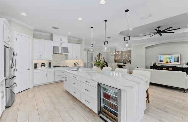 a large kitchen with kitchen island a white counter space a sink appliances and cabinets