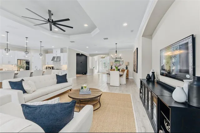 a living room with furniture kitchen view and a large window