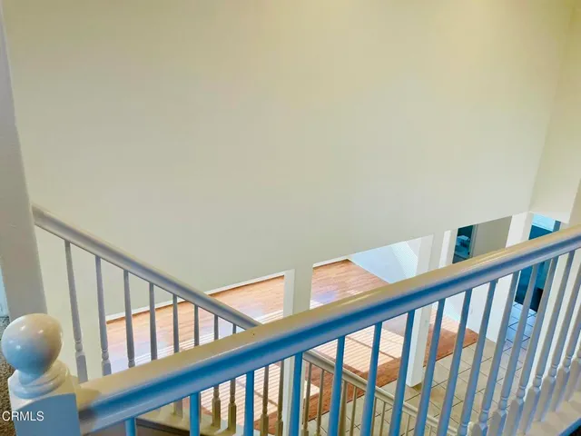 a view of staircase with railing and white walls