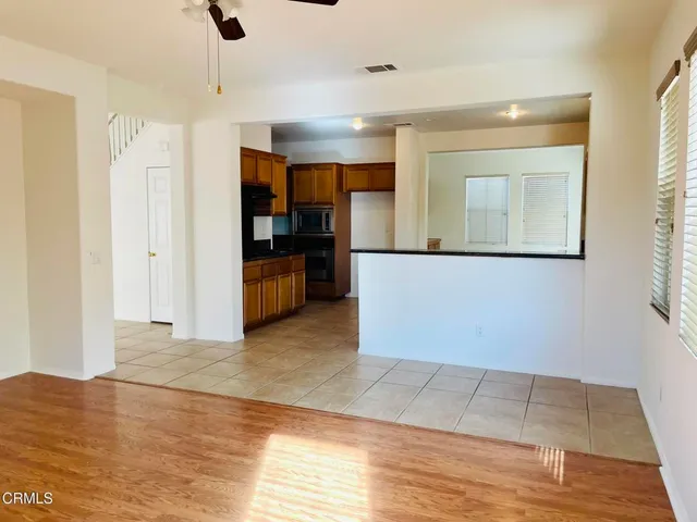a view of a hallway with wooden floor and cabinet