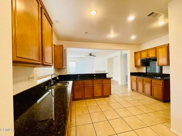a kitchen with a sink a stove top oven a counter top space and cabinets