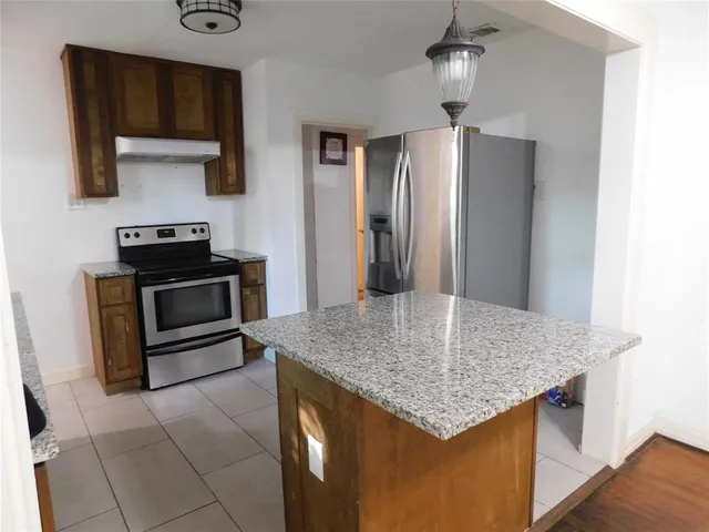 a kitchen with stainless steel appliances granite countertop a sink dishwasher stove and refrigerator