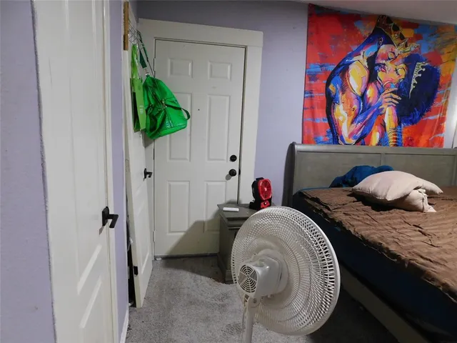 a bedroom with a bed and a painting on the wall