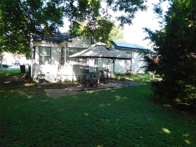 a view of a patio with table and chairs under an umbrella