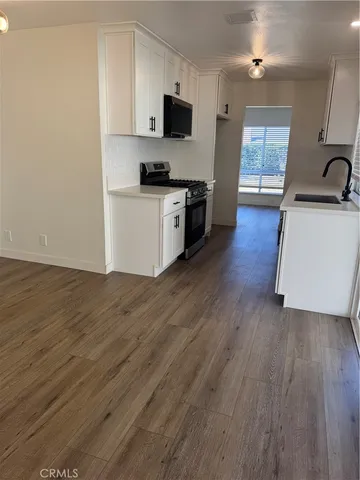 a kitchen with stainless steel appliances a sink a stove a refrigerator and cabinets