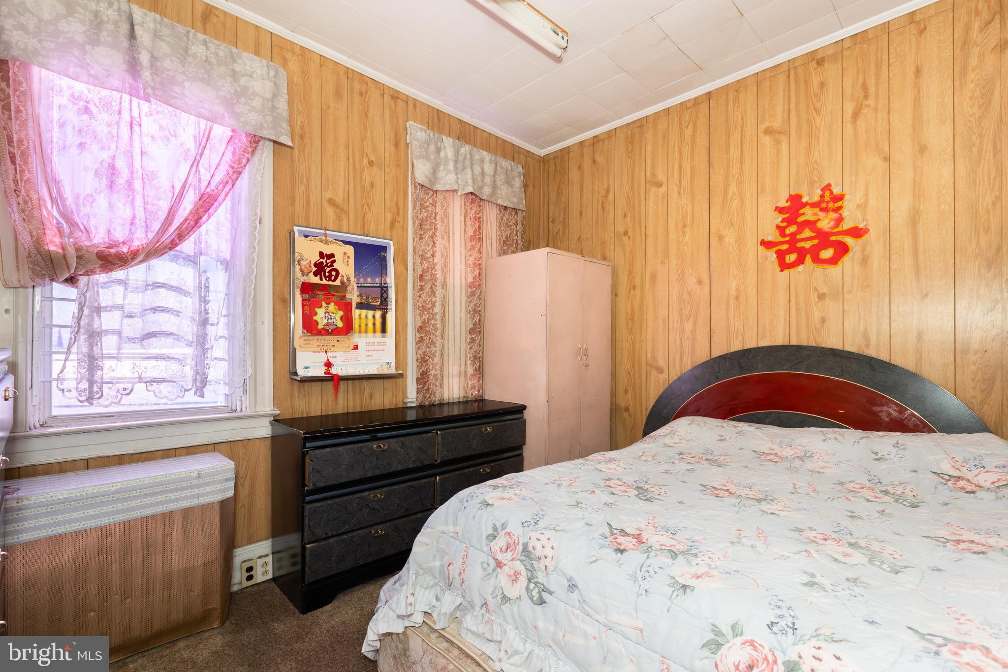 505 East 35th Street Baltimore, MD 21218 - Photo 26 of 45 a bedroom with a bed and a dresser with wooden floor