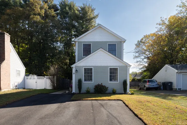 a front view of a house with a yard and trees