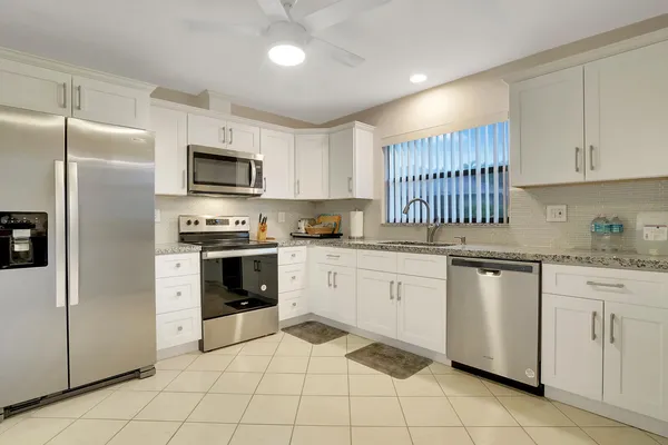 a kitchen with granite countertop cabinets stainless steel appliances and a counter space