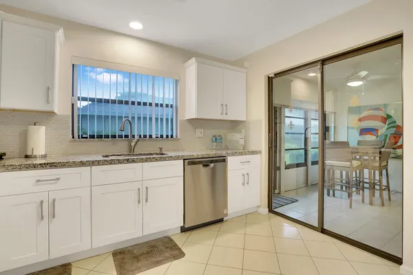 a kitchen with granite countertop a sink a stove cabinets and stainless steel appliances