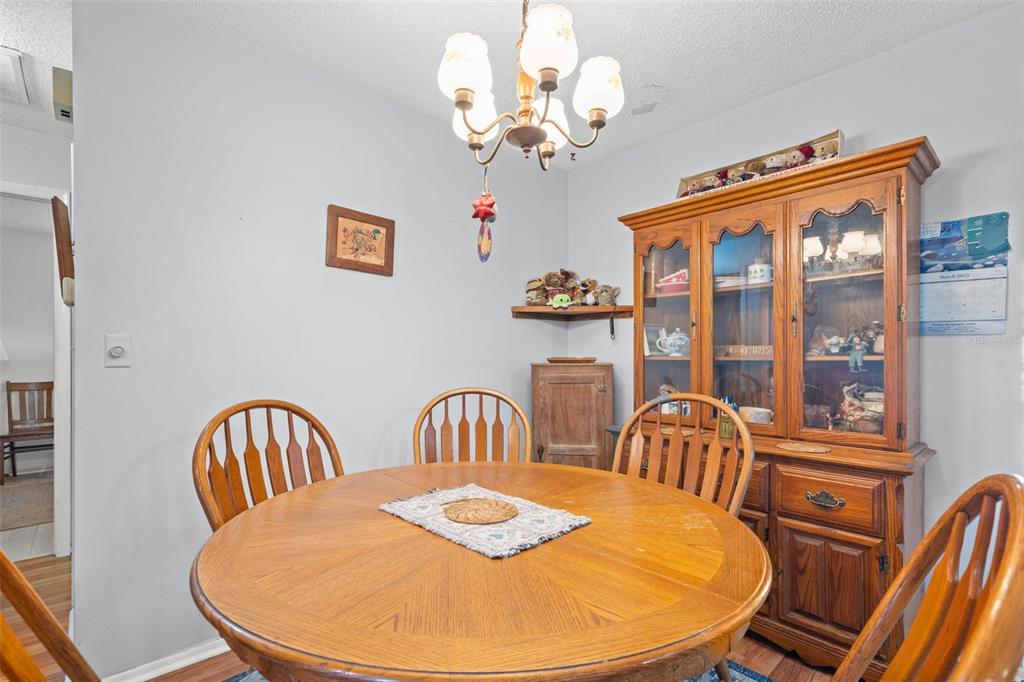 9061 Byron Street Spring Hill, FL 34606 - Photo 12 of 43 a view of a dining room with furniture a chandelier and wooden floor