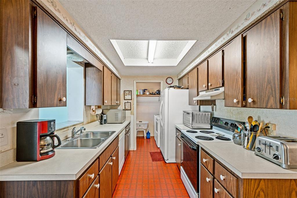 9061 Byron Street Spring Hill, FL 34606 - Photo 17 of 43 a kitchen with stainless steel appliances granite countertop a sink stove and refrigerator