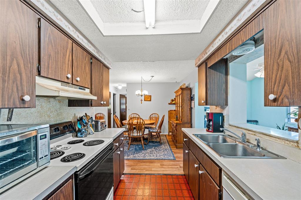 9061 Byron Street Spring Hill, FL 34606 - Photo 19 of 43 a kitchen with stainless steel appliances granite countertop a sink stove and cabinets